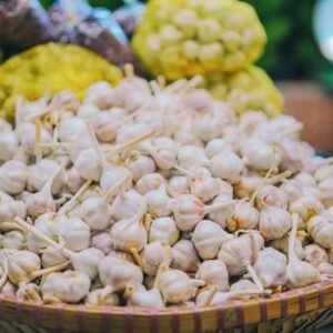 A large pile of fresh garlic bulbs on display at a local market, ready for sale.